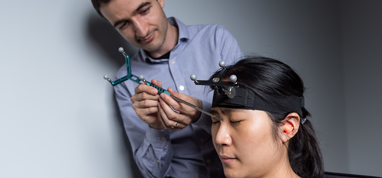 Researcher measuring the brain stimulation of the human subject