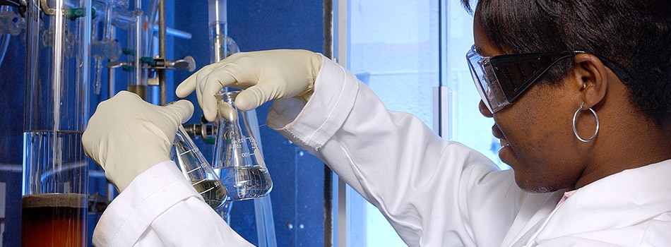 Research student comparing the levels of liquid in two different flasks